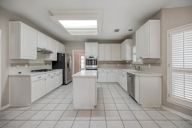 a kitchen with a stove sink cabinets and window