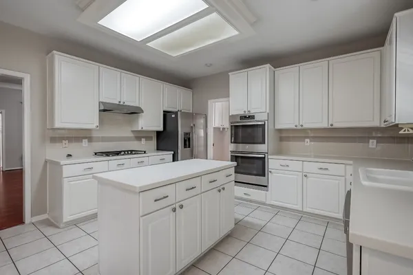 a kitchen with white cabinets and white appliances