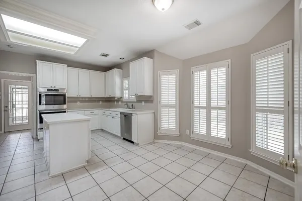 a kitchen with white cabinets and white appliances