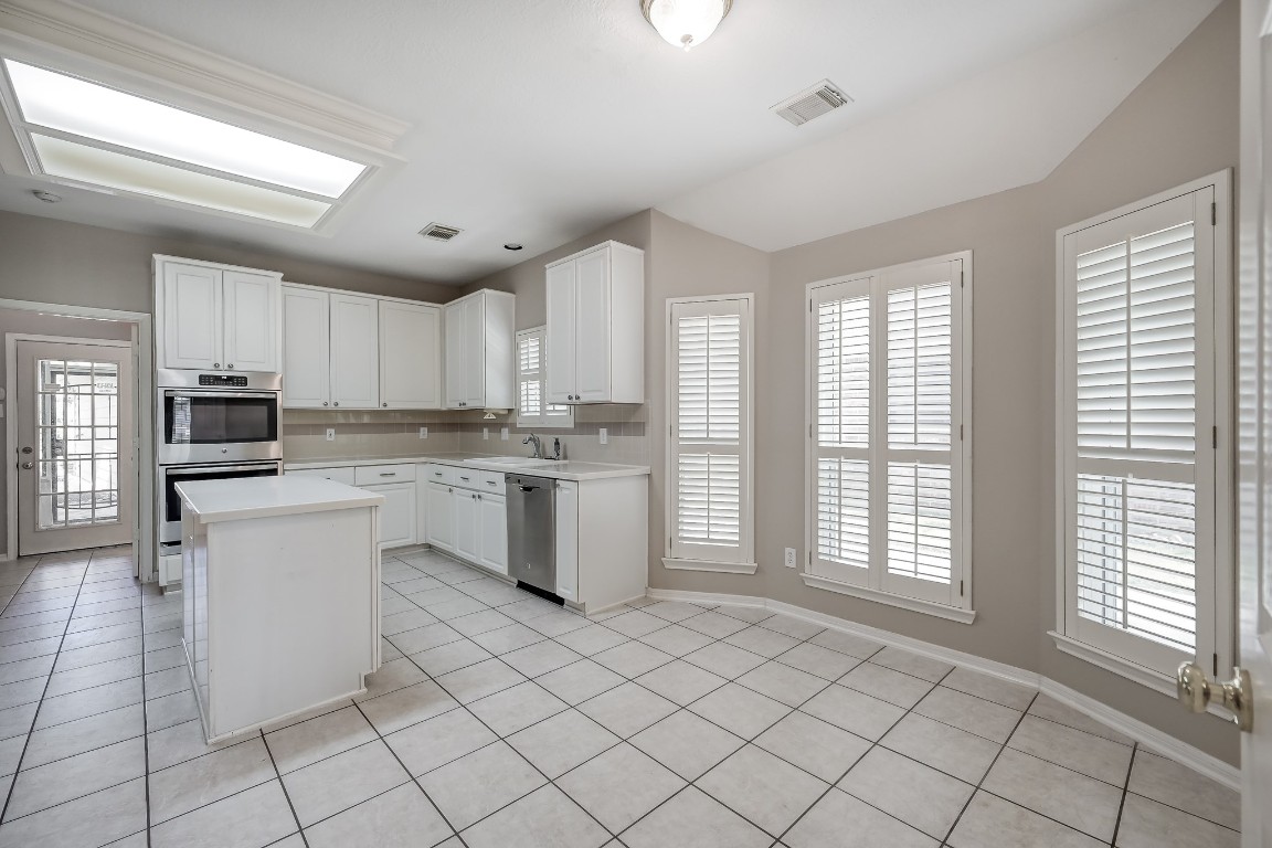 3510 Ash Glen Drive Spring, TX 77388 - Photo 21 of 39 a kitchen with white cabinets and white appliances