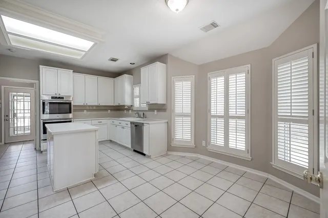 a kitchen with white cabinets and white appliances