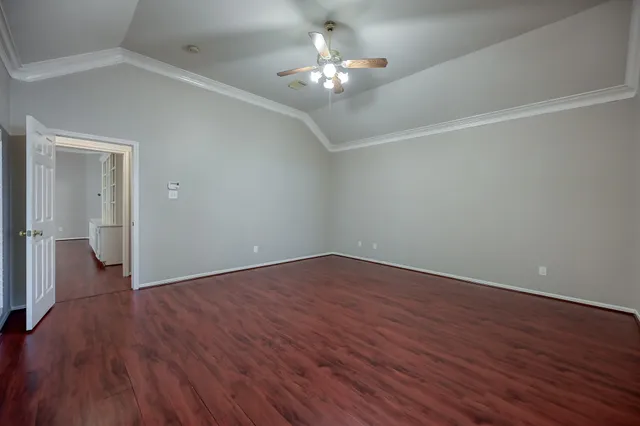 a view of an empty room with wooden floor