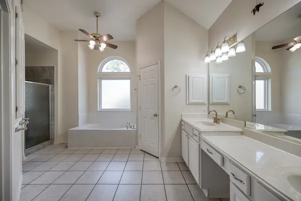 a spacious bathroom with a granite countertop sink a toilet a mirror and shower