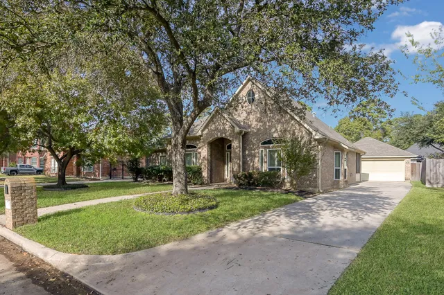 a front view of a house with a yard and trees