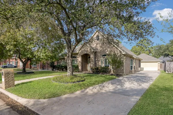 a front view of a house with a yard and trees