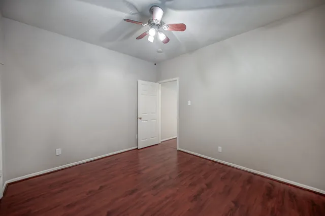 a view of a room with wooden floor and a ceiling fan