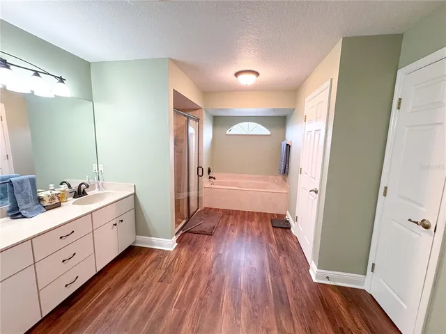 a kitchen with granite countertop a refrigerator stove and wooden floor