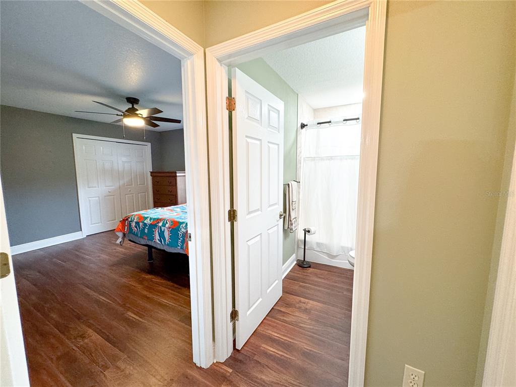 6282 Northeast 61st Ave Road Silver Springs, FL 34488 - Photo 35 of 73 a view of a hallway to a livingroom with wooden floor and a cabinet