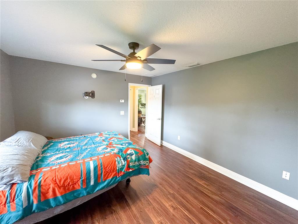 6282 Northeast 61st Ave Road Silver Springs, FL 34488 - Photo 40 of 73 a bedroom with a bed and a chandelier