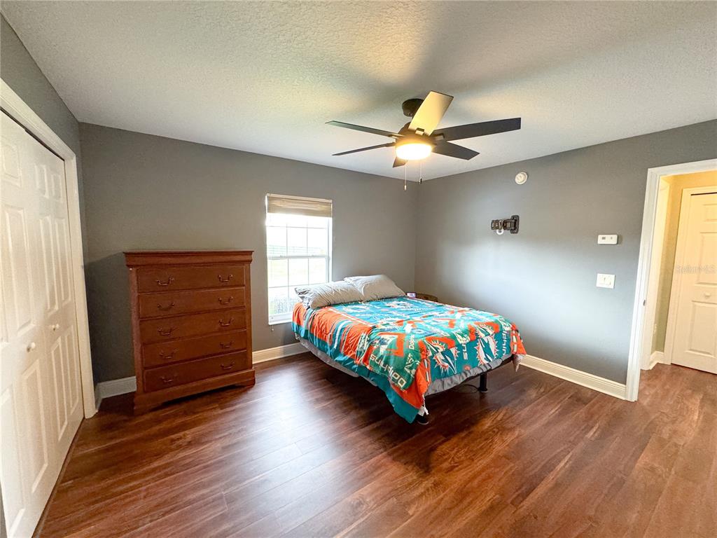 6282 Northeast 61st Ave Road Silver Springs, FL 34488 - Photo 41 of 73 a bedroom with a bed and wooden floor