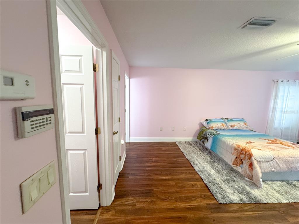 6282 Northeast 61st Ave Road Silver Springs, FL 34488 - Photo 50 of 73 a bedroom with a bed and wooden floor