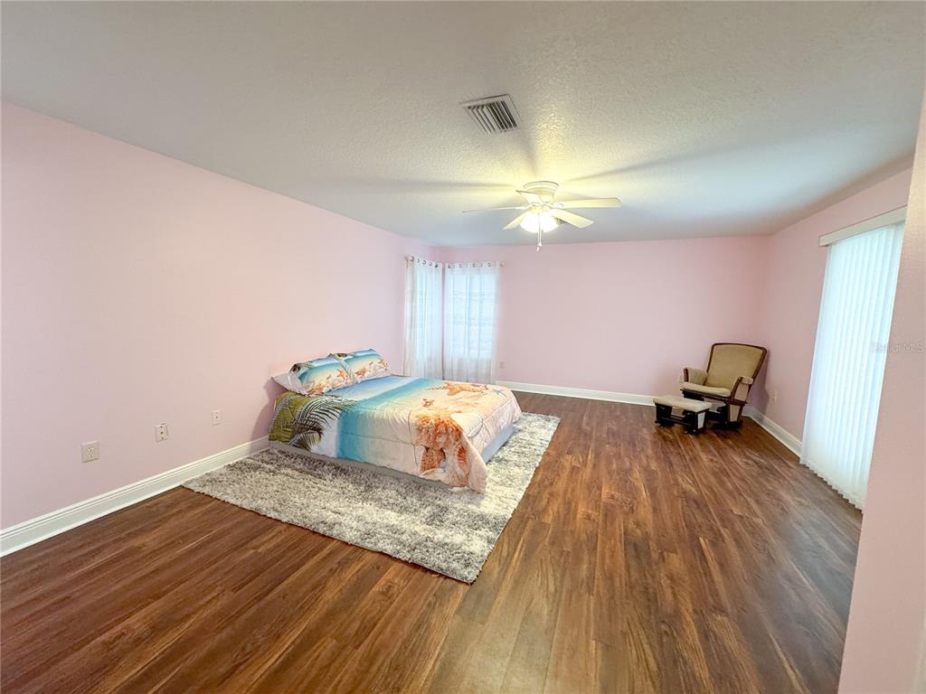 6282 Northeast 61st Ave Road Silver Springs, FL 34488 - Photo 52 of 73 a bedroom with a bed and a chandelier