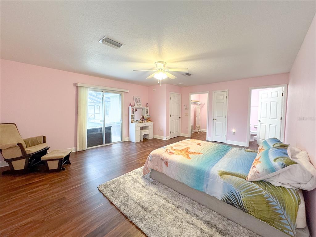 6282 Northeast 61st Ave Road Silver Springs, FL 34488 - Photo 54 of 73 a spacious bedroom with a bed and wooden floor