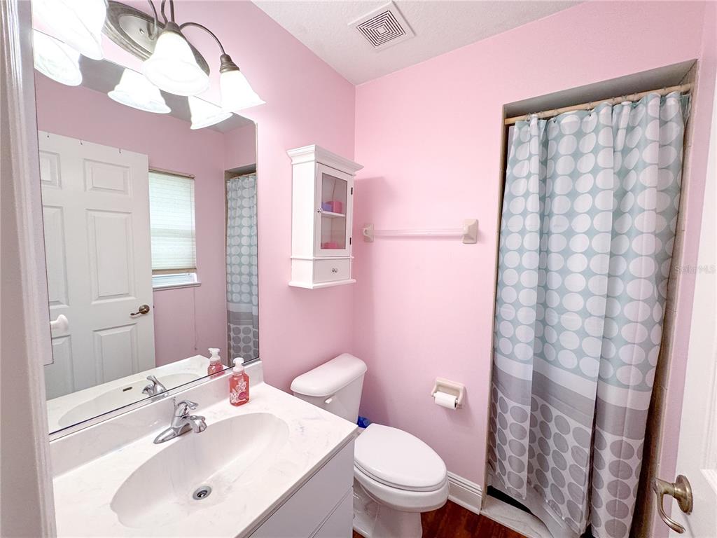 6282 Northeast 61st Ave Road Silver Springs, FL 34488 - Photo 57 of 73 a bathroom with a sink a toilet and shower curtain