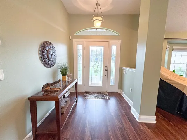 a view of a livingroom with furniture wooden floor front door and a window