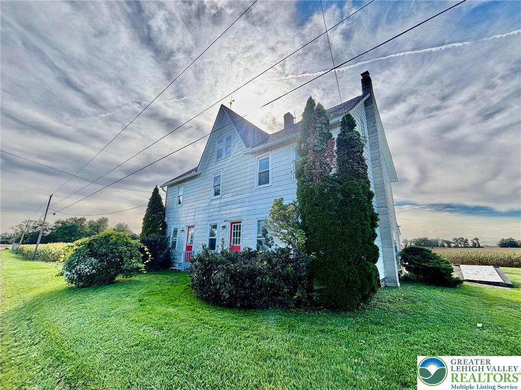 4067 Newburg Road Bethlehem, PA 18020 - Photo 2 of 19 A classic multi-story facade rises above a grassy lawn under a dramatic sky.