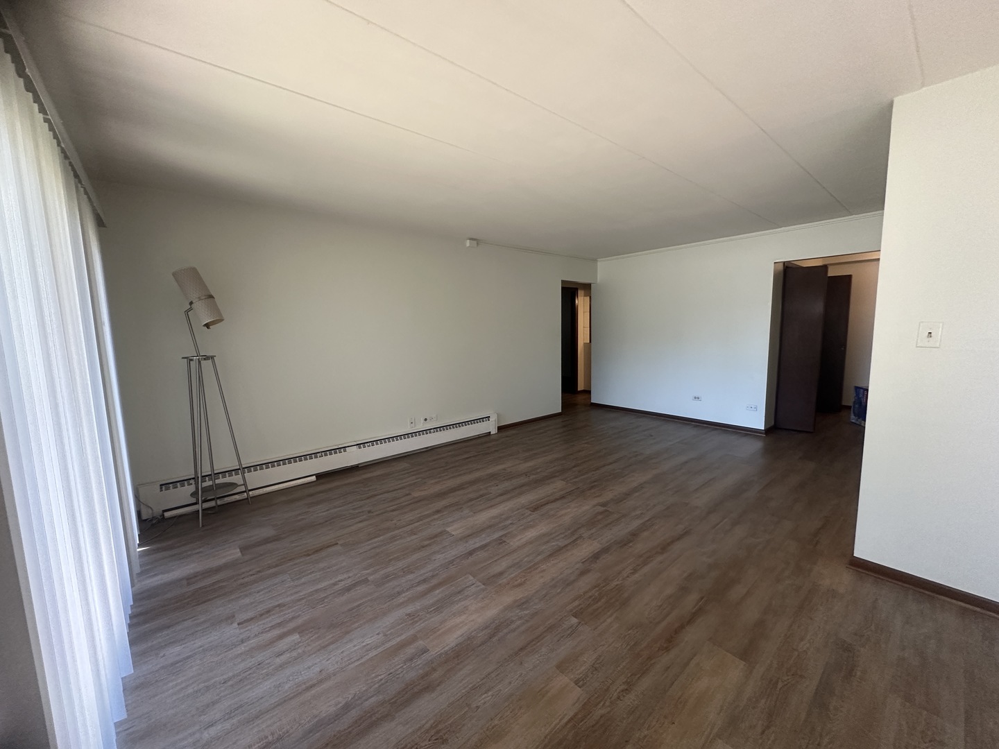 18550 Torrence Avenue, Unit 4 Lansing, IL 60438 - Photo 9 of 14 a view of an empty room with wooden floor and a window