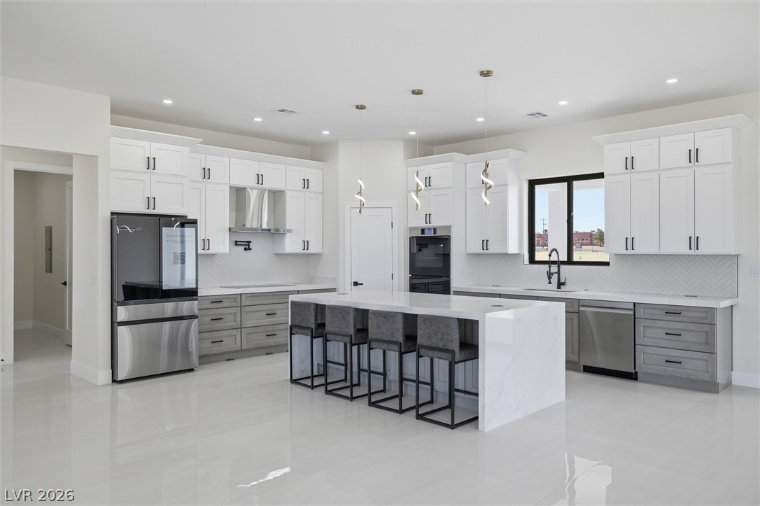 5910 East Kellogg Road Pahrump, NV 89061 - Photo 15 of 58 A well-lit, contemporary kitchen boasts a spacious island with seating and sleek, modern appliances.