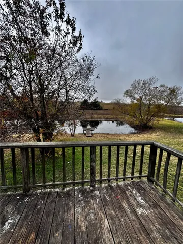 a view of balcony with wooden floor and fence