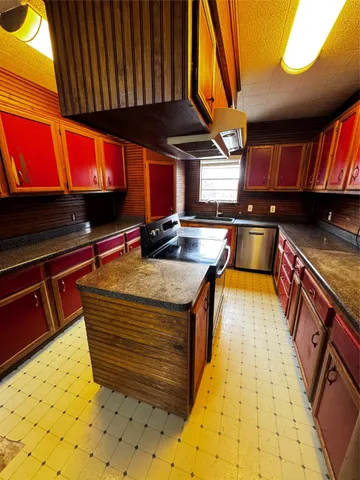 a kitchen with stainless steel appliances kitchen island granite countertop a sink stove and cabinets