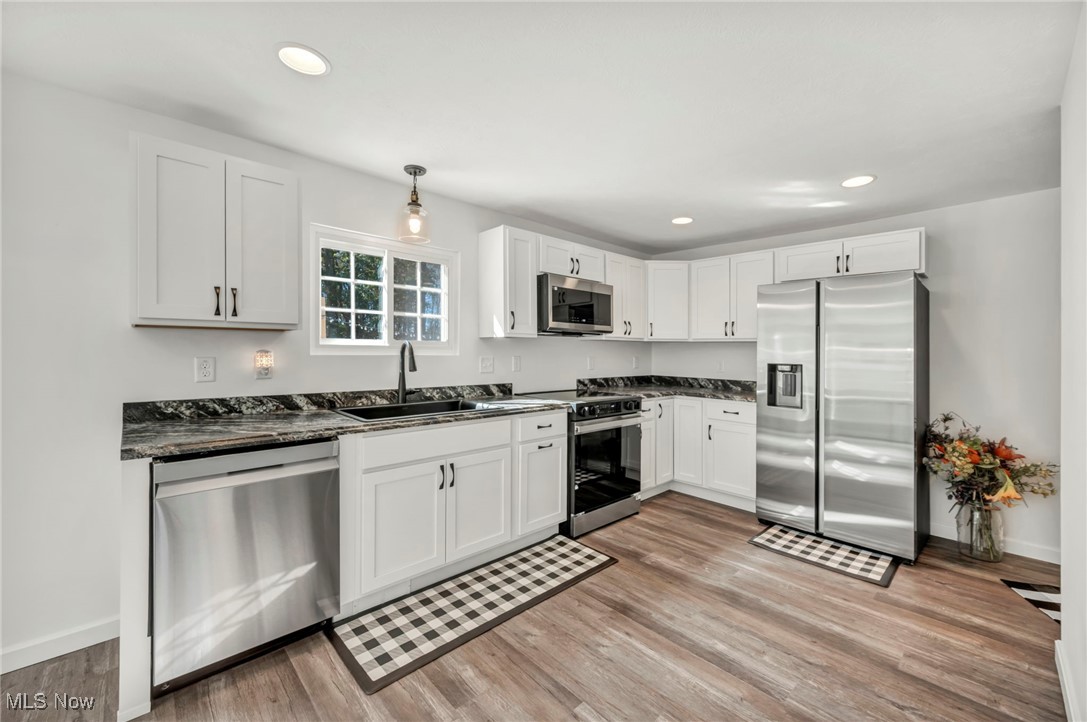 43575 Cream Ridge Road Lisbon, OH 44432 - Photo 17 of 50 Kitchen with appliances with stainless steel finishes, white cabinets, recessed lighting, pendant lighting, and light wood finished floors