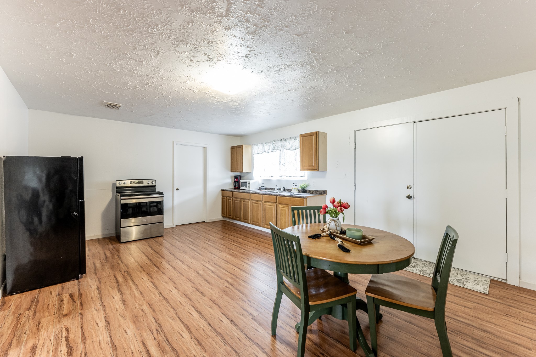 20471 Roy Hall Road Bedias, TX 77831 - Photo 9 of 24 a kitchen with a dining table chairs and refrigerator