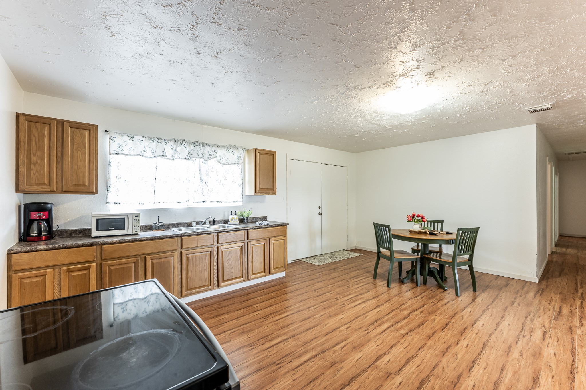 20471 Roy Hall Road Bedias, TX 77831 - Photo 10 of 24 a kitchen with stainless steel appliances granite countertop a kitchen island hardwood floor sink stove dining table and chairs