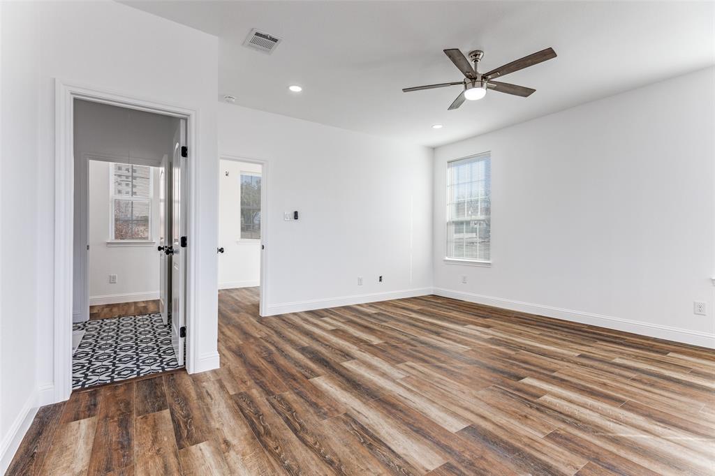 2612 Burchill Road Fort Worth, TX 76105 - Photo 12 of 25 a view of a hallway to a bedroom with wooden floor and a ceiling fan