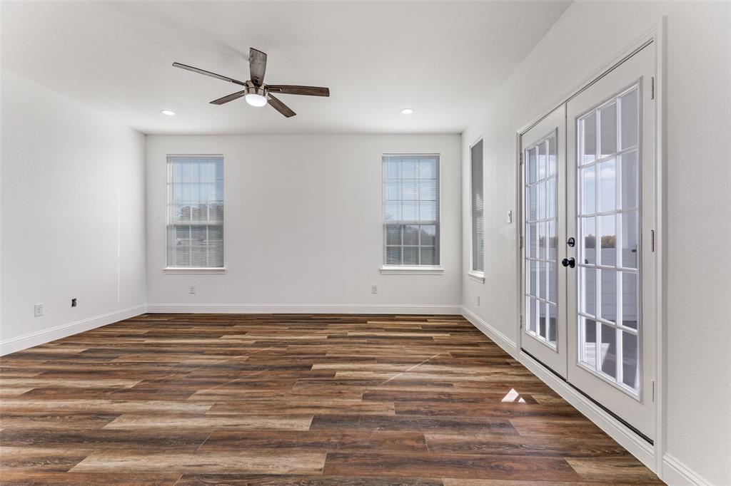 2612 Burchill Road Fort Worth, TX 76105 - Photo 13 of 25 a view of an empty room with wooden floor and a window