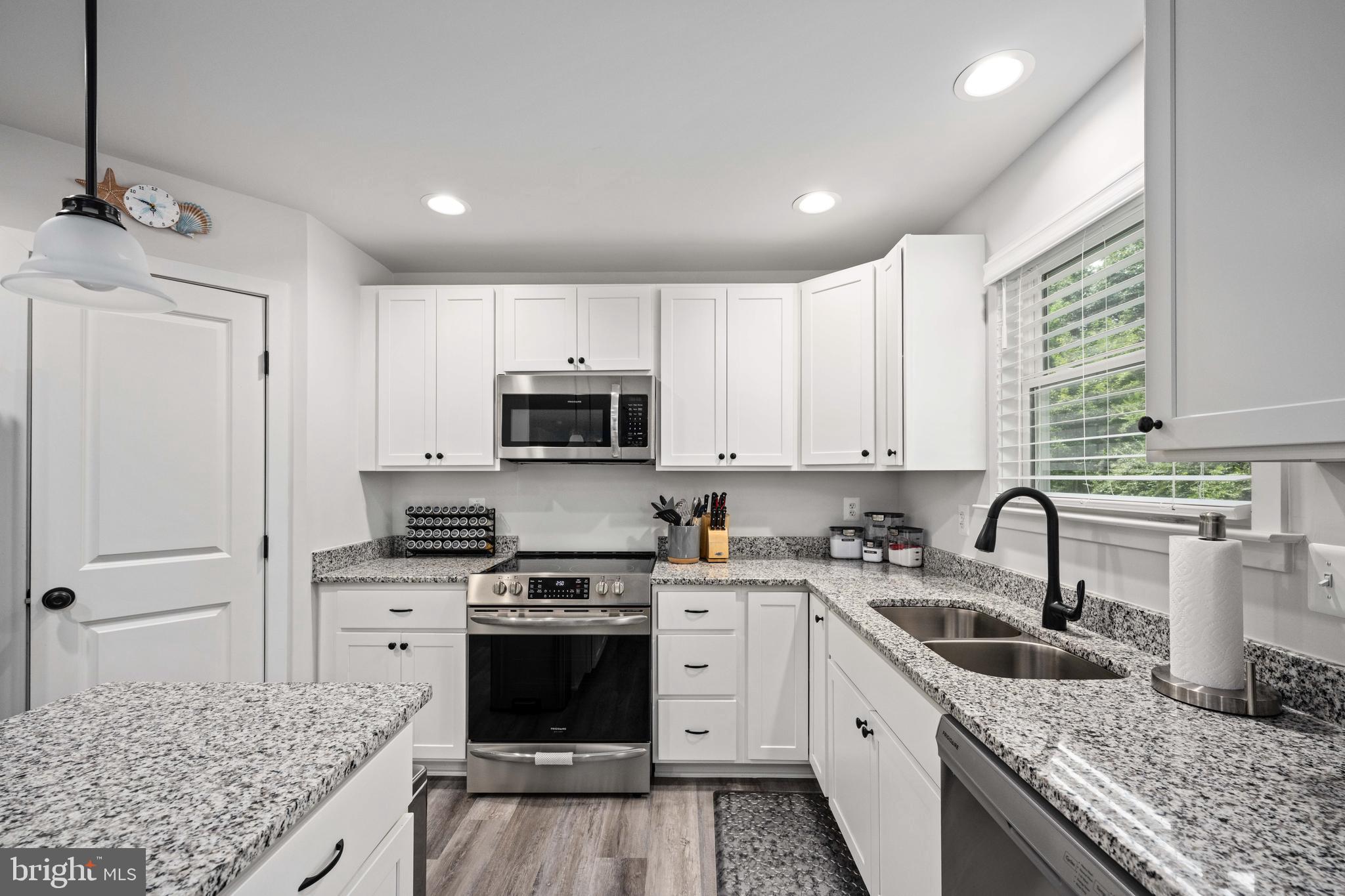 133 7th Street Colonial Beach, VA 22443 - Photo 26 of 72 a kitchen with stainless steel appliances granite countertop a sink stove and refrigerator