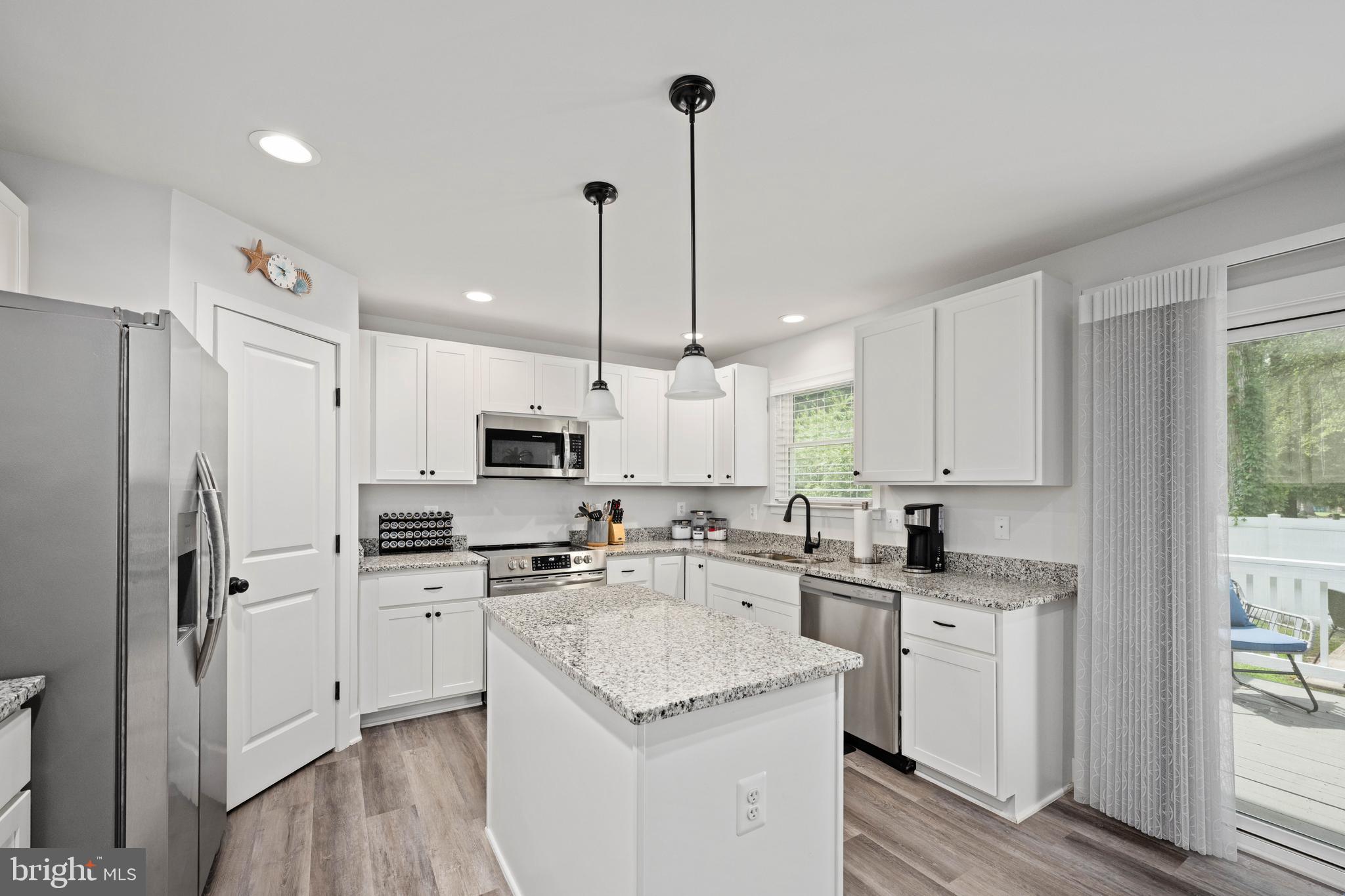 133 7th Street Colonial Beach, VA 22443 - Photo 28 of 72 a kitchen with white cabinets sink and stainless steel appliances