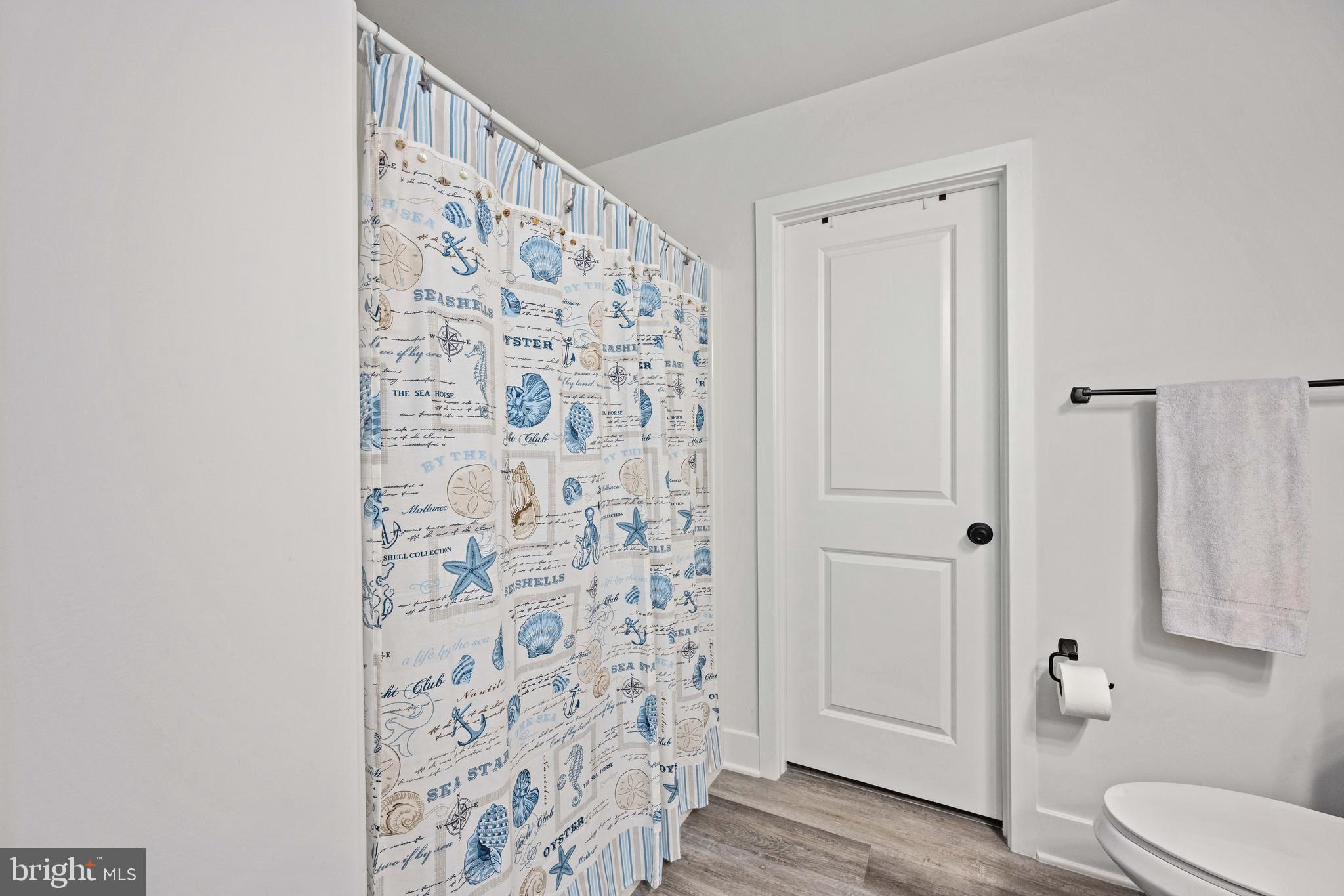 133 7th Street Colonial Beach, VA 22443 - Photo 39 of 72 a bathroom with a shower curtain and a toilet