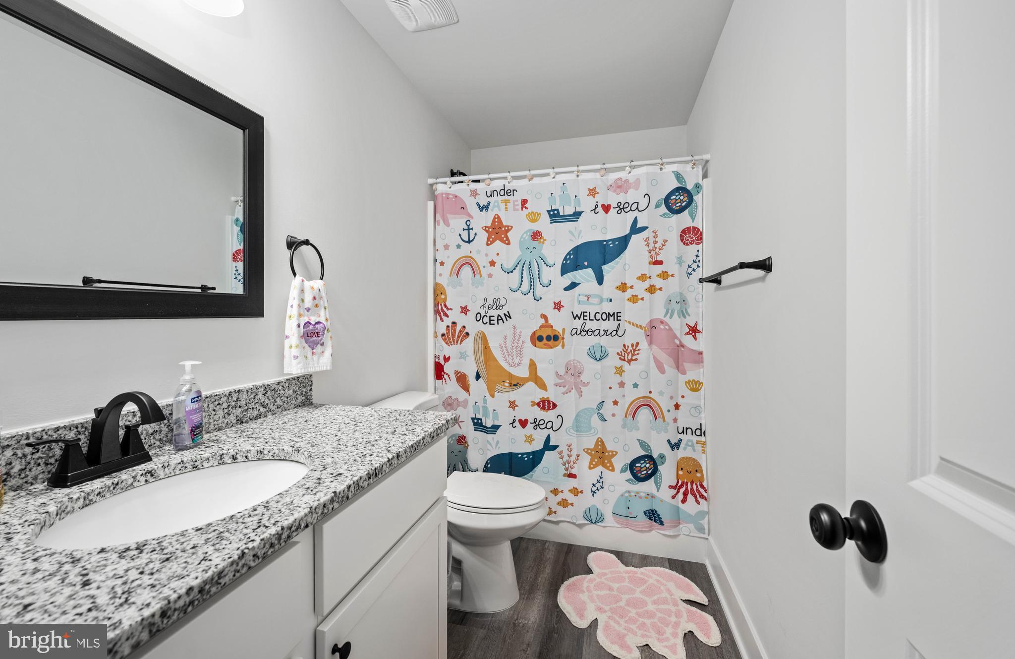 133 7th Street Colonial Beach, VA 22443 - Photo 47 of 72 a bathroom with a granite countertop toilet sink and mirror