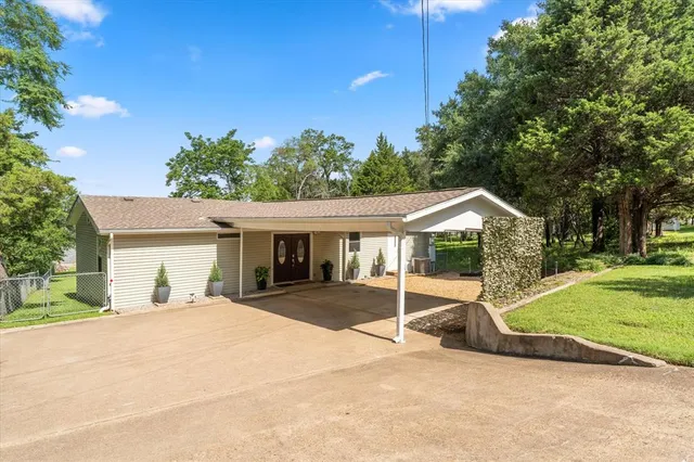 a view of a house with a yard and potted plants