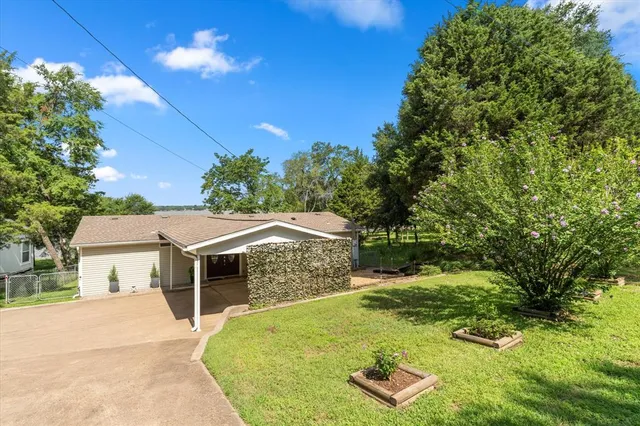 a view of a white house with a yard and potted plants