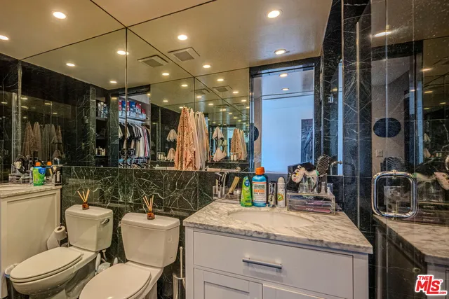 a bathroom with a toilet sink and mirror