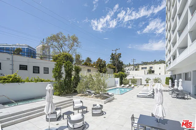 a view of a patio with couches table and chairs and potted plants