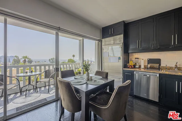 a dining room with furniture a floor to ceiling window and wooden floor