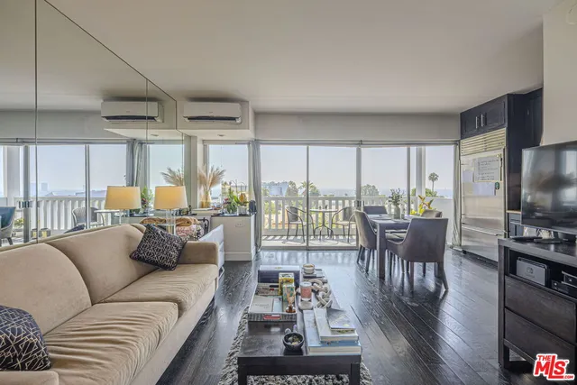 a living room with furniture a flat screen tv and a large window