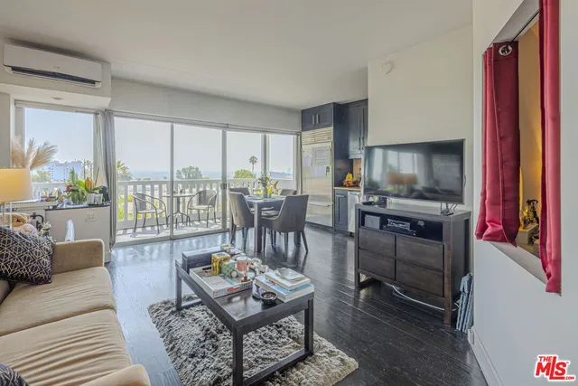 a living room with furniture a flat screen tv and a floor to ceiling window