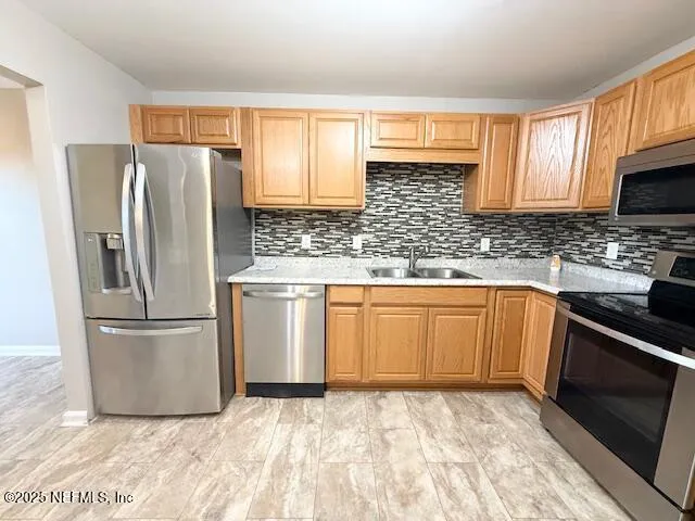 a kitchen with stainless steel appliances granite countertop a stove sink and microwave