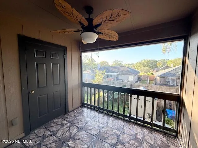 a view of a hallway with a chandelier fan and glass door
