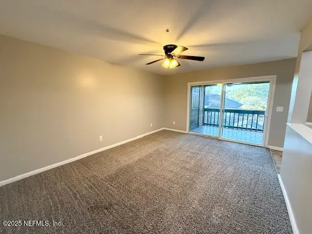 a view of a big room with wooden floor and chandelier fan