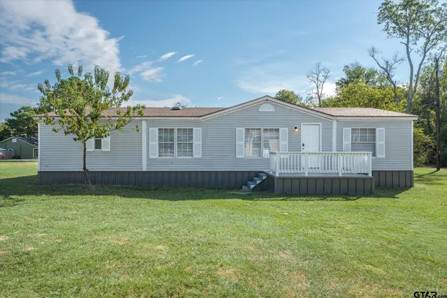 a view of a house with a yard and sitting area