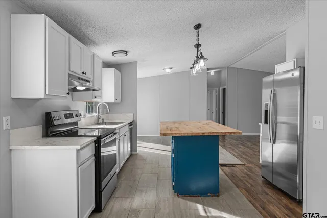 a kitchen with stainless steel appliances a sink stove and refrigerator