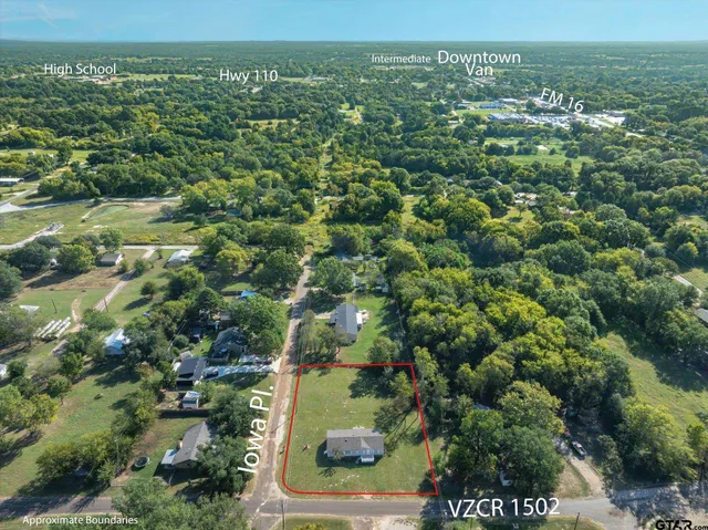 an aerial view of residential houses with outdoor space and trees