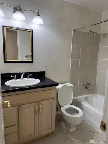 a bathroom with a toilet sink vanity tub and mirror
