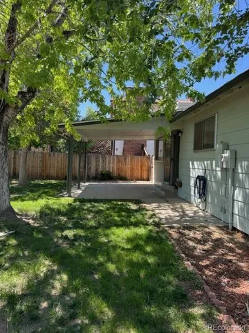 a view of a house with backyard and a tree