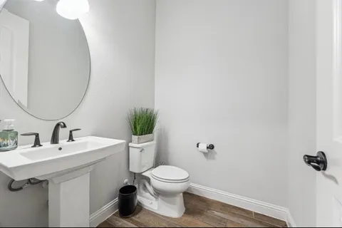 a bathroom with a toilet a sink and mirror