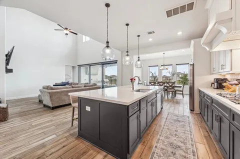 a kitchen with kitchen island granite countertop a sink and a stove